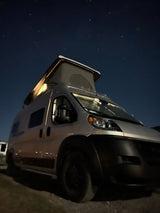Starry night over an RV rental: a silver pop-top camper van, subtly lit. Ideal for remote camping adventures.