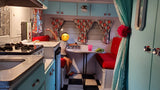 Child playing checkers inside a charming, retro rv rental, featuring a kitchen, red dinette, and checkered floor.