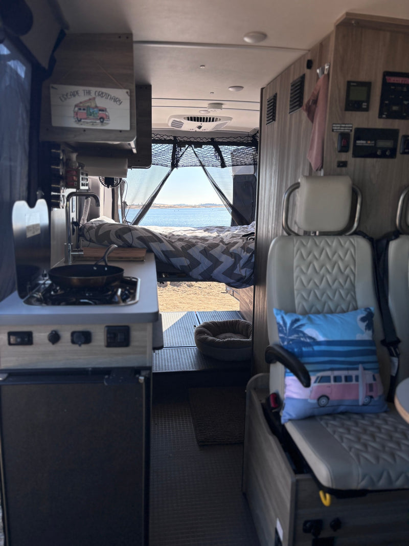 Cozy rv rental interior: kitchen, lake-view bed, and dog bed. 'Escape the Ordinary' van life awaits. — photo 3
