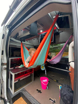 Kids enjoy colorful hammocks inside this cozy **rv rental**'s custom interior, great for family adventures.