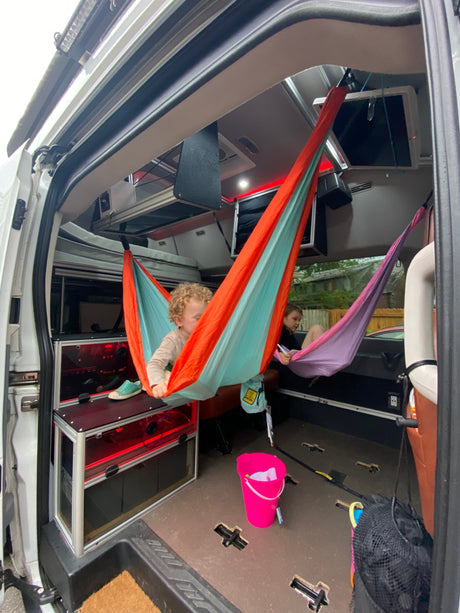 Kids enjoy colorful hammocks inside this cozy **rv rental**'s custom interior, great for family adventures.