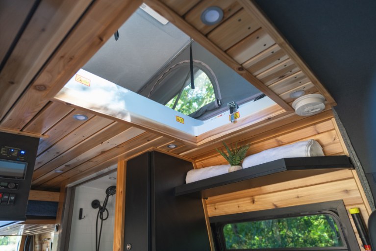  showcasing its versatile design for an RV rental. Amidst green trees.|Close-up of a Mercedes-Benz Sprinter van with textured hood — photo 14