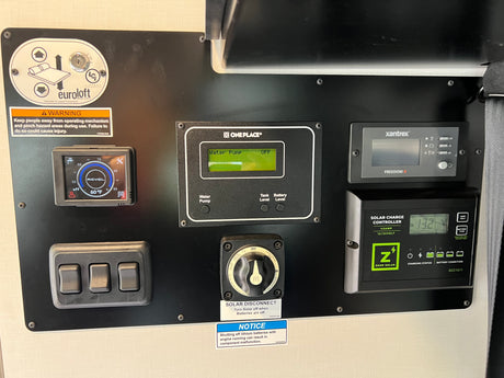 RV rental control panel: displays for water, solar, battery; switches for pump & Euroloft bed lift. Comprehensive RV management.