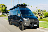 Robust, custom Mercedes Sprinter adventure van, ideal for RV rental. Equipped with off-road tires and roof gear for journeys.