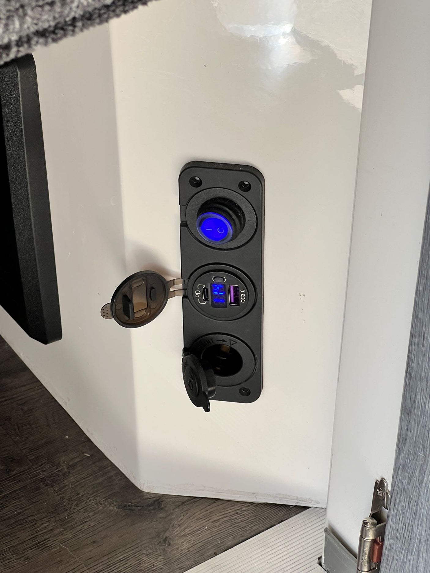 RV rental power hub: illuminated switch, USB charging with voltage display (12.4V), and 12V auxiliary outlet.