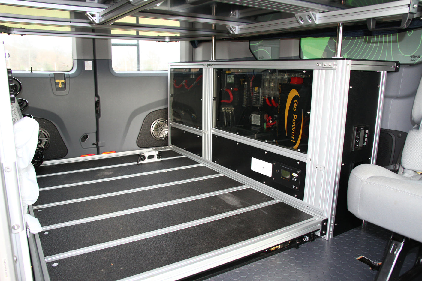 Custom RV rental interior: power system with Go Power inverter, solar controller, and modular bed platform.