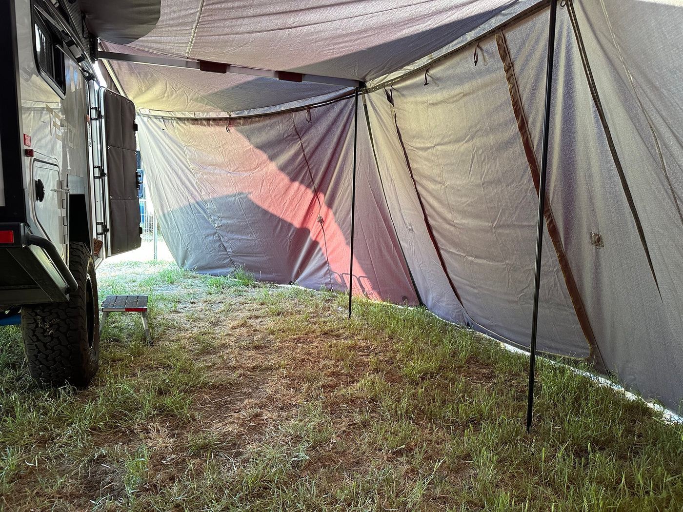 Inside a shaded RV rental annex on a grassy campsite, providing extended outdoor living space. — photo 16