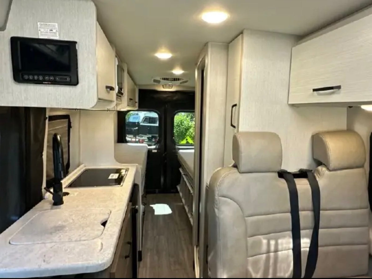  and toilet paper dispenser.|Functional RV rental wet bath featuring a handheld shower and mirror — photo 7
