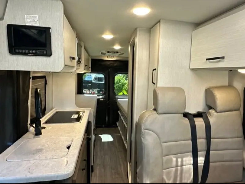  and toilet paper dispenser.|Functional RV rental wet bath featuring a handheld shower and mirror — photo 7