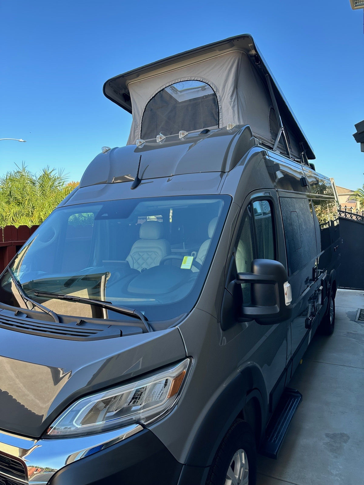 This modern gray camper van with an extended pop-top roof is ready for your next rv rental adventure.|Up-close view of a modern