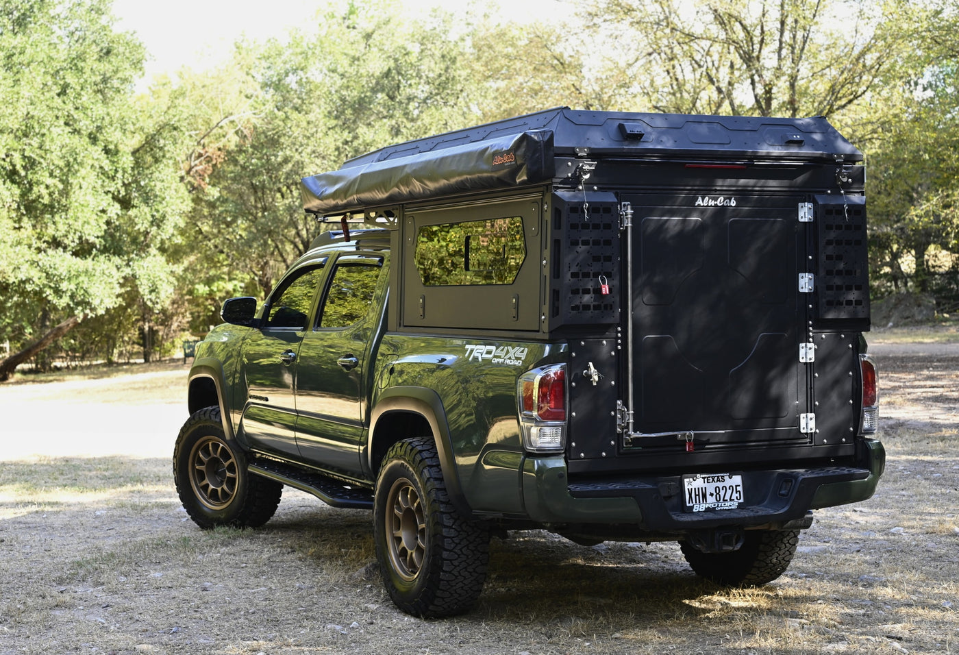 Green Toyota Tacoma 4x4 Off-Road with Alu-Cab truck camper, perfect for rugged rv rental adventures. — photo 7