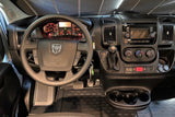 RV rental Dodge Ram ProMaster van dashboard shows the steering wheel, infotainment screen, climate controls, and gear shifter.