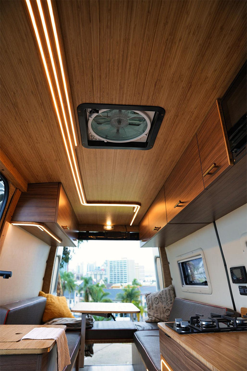  with a vibrant orange sky & dramatic clouds.|Modern rv rental interior: This cozy campervan features warm wood paneling — photo 2
