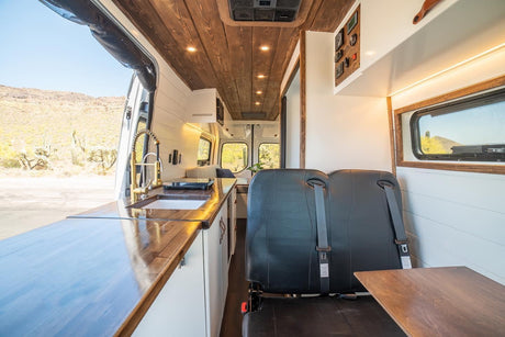 Spacious RV rental with a sleek kitchen, cozy seating, and wooden details, perfect for desert adventures.