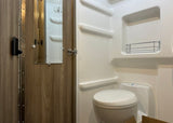 Compact RV rental bathroom with toilet, shower, and mirrored door. Ideal for travel comfort.