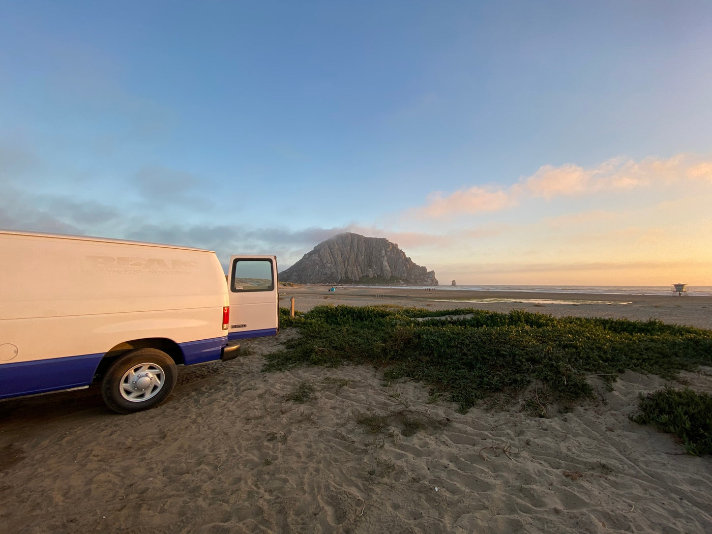 An RV rental van parked on a sandy beach, overlooking Morro Rock & the ocean at sunset. — photo 13