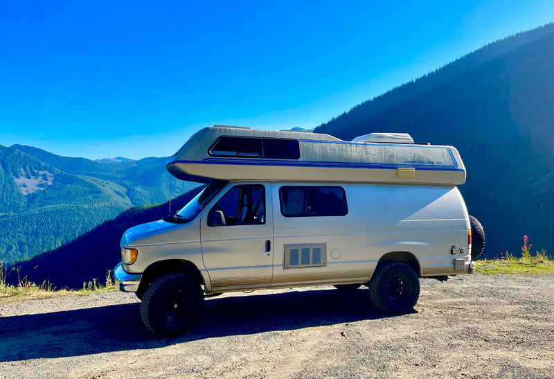  parked in a dark forest against a twilight sky. Peaceful camping journey.|Silver Airstream camper van on a dirt road — photo 3