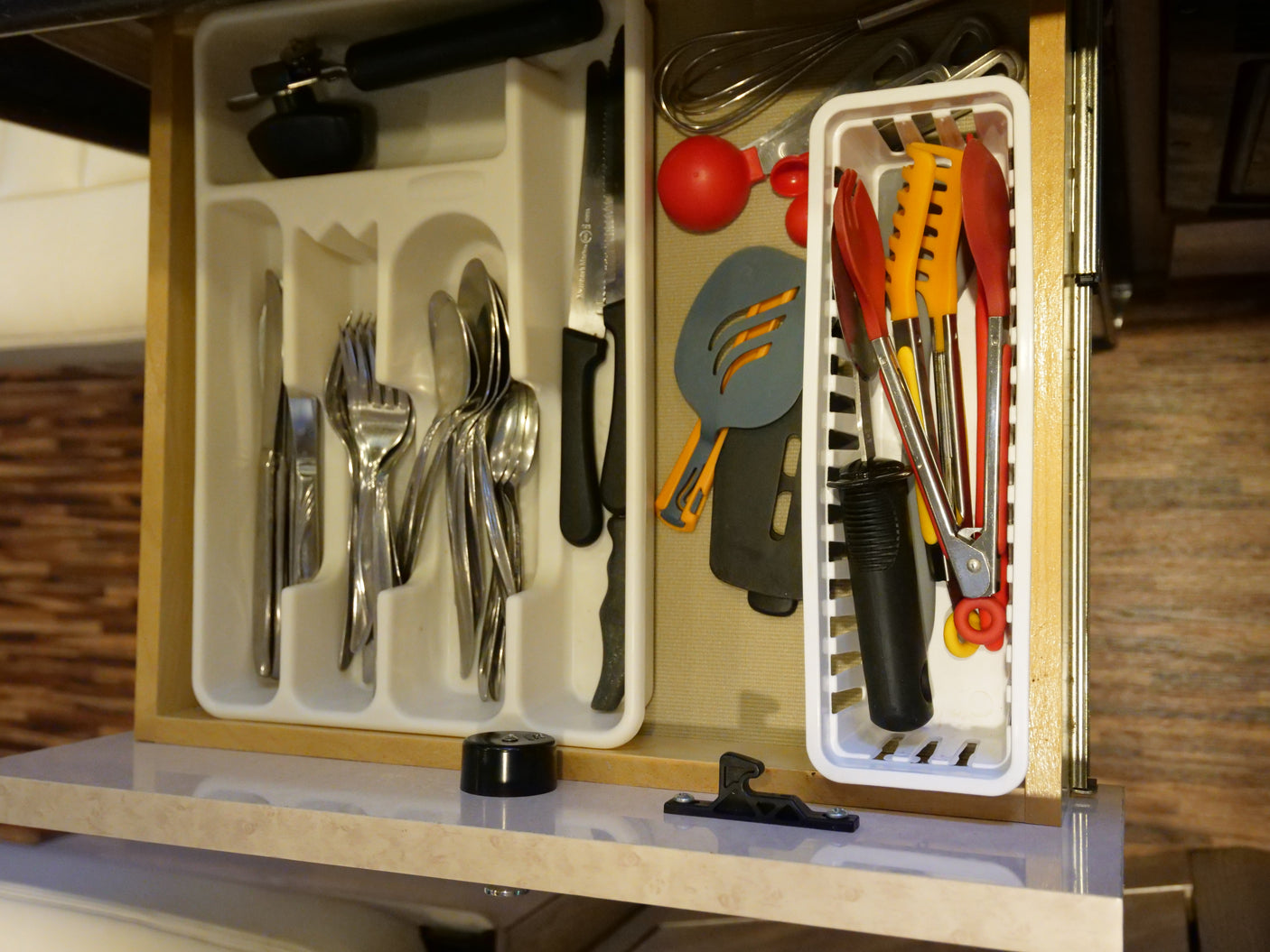 RV rental kitchen drawer neatly organized with cutlery, spatulas, and cooking utensils, ensuring convenience.