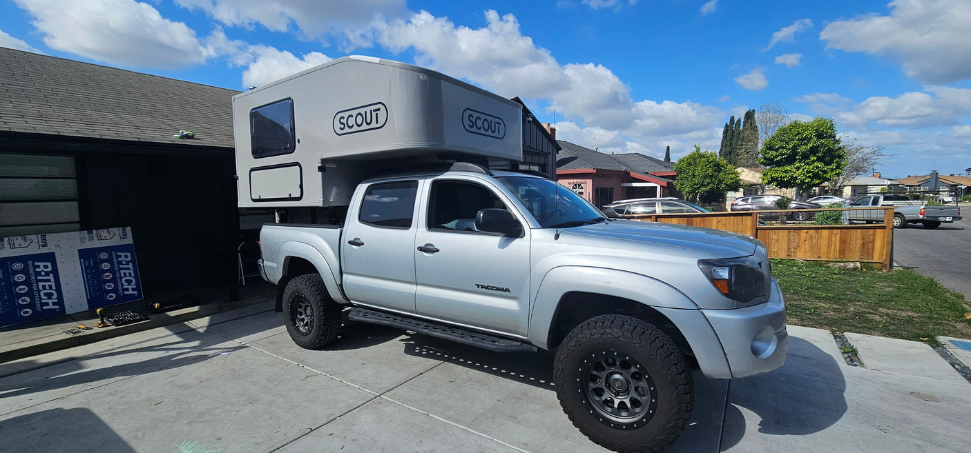 Silver Toyota Tacoma truck with a Scout camper, ideal for an rv rental, overlanding, or outdoor adventures.