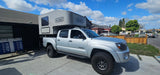 Silver Toyota Tacoma truck with a Scout camper, ideal for an rv rental, overlanding, or outdoor adventures.