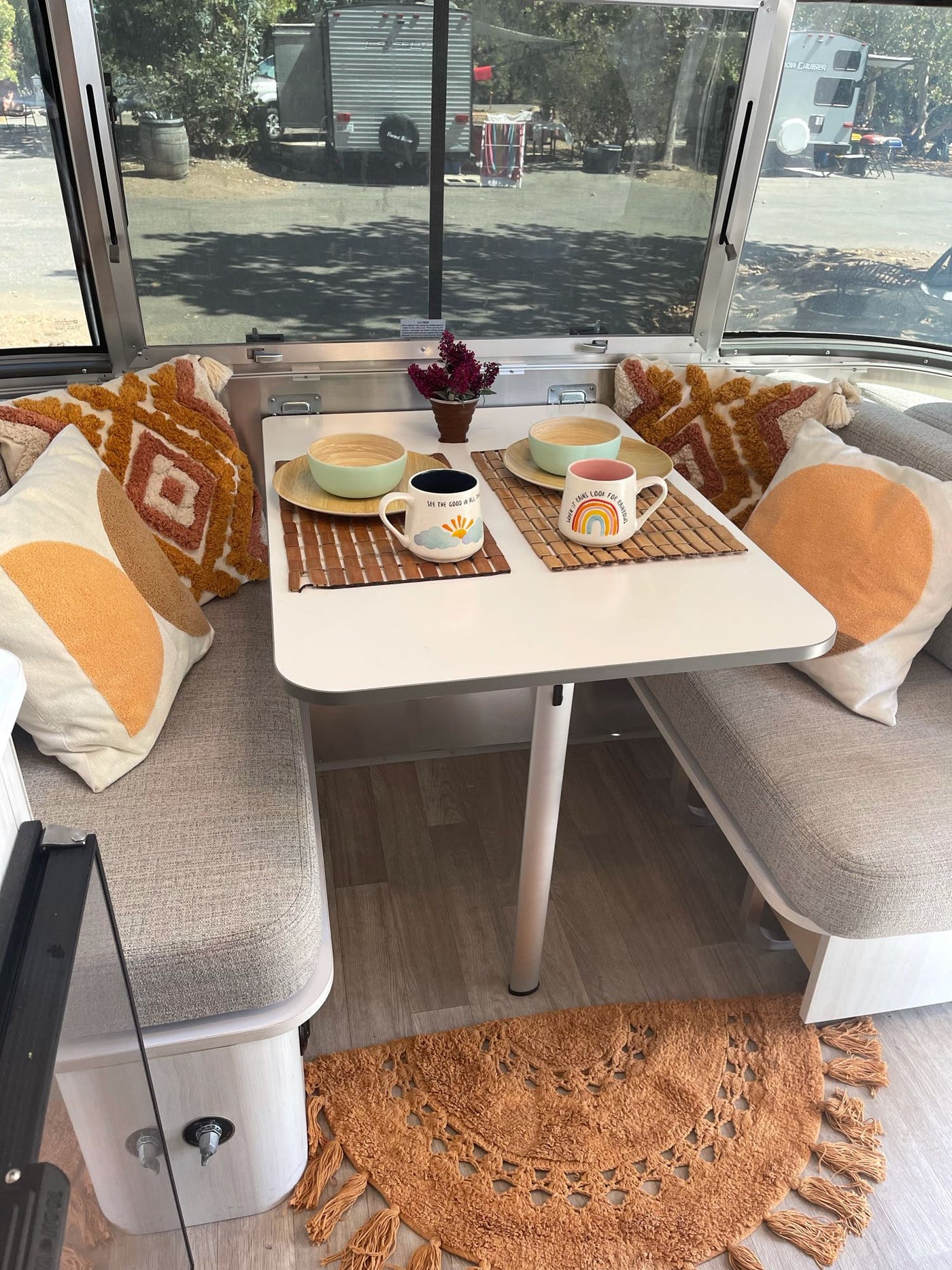  and a fringed rug. Joshua trees visible outside.|A cozy Airstream rv rental bed with sunburst blanket — photo 20