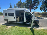 White camper van with open doors parked on a sunny street, ready for adventure. Ideal for an rv rental.