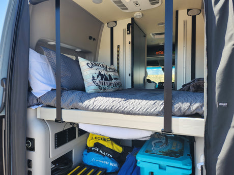 Inside your RV rental: a comfy bed, fresh water, and essential supplies in a well-organized