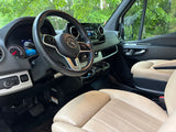RV rental: Driver's view of a modern Mercedes-Benz Sprinter van interior, featuring its dashboard & steering wheel.