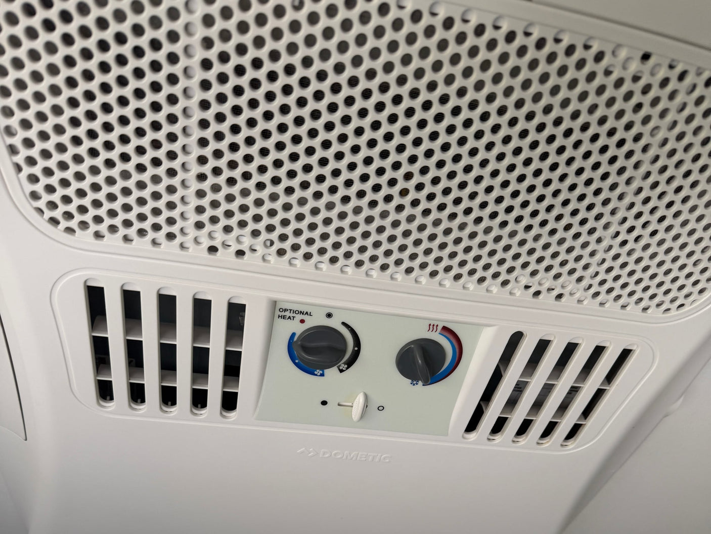  and AC unit on the ceiling.|A Dometic Evolution RV air conditioner mounted on a white RV rental roof