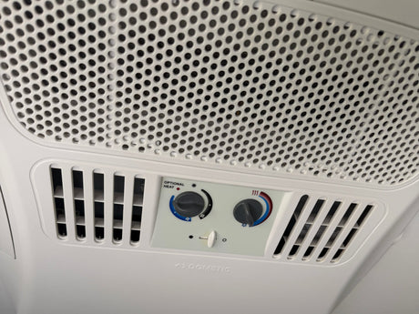  and AC unit on the ceiling.|A Dometic Evolution RV air conditioner mounted on a white RV rental roof