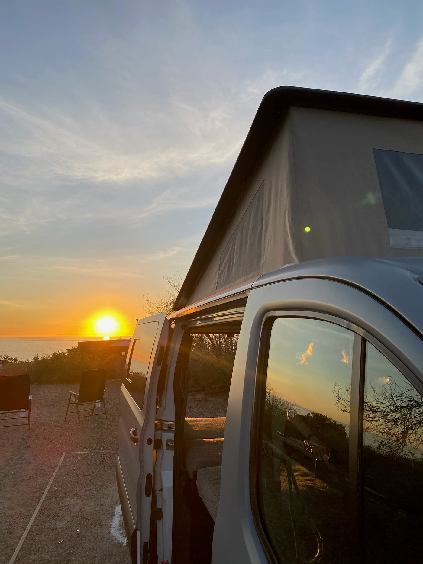 Stunning ocean sunset from an RV rental with a pop-top, golden light reflecting beautifully on windows. — photo 6
