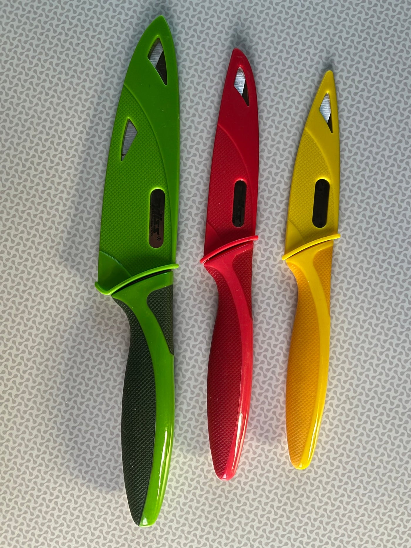 Three vibrant green, red, and yellow kitchen knives displayed. Great for cooking at home or on your next RV rental adventure! — photo 10