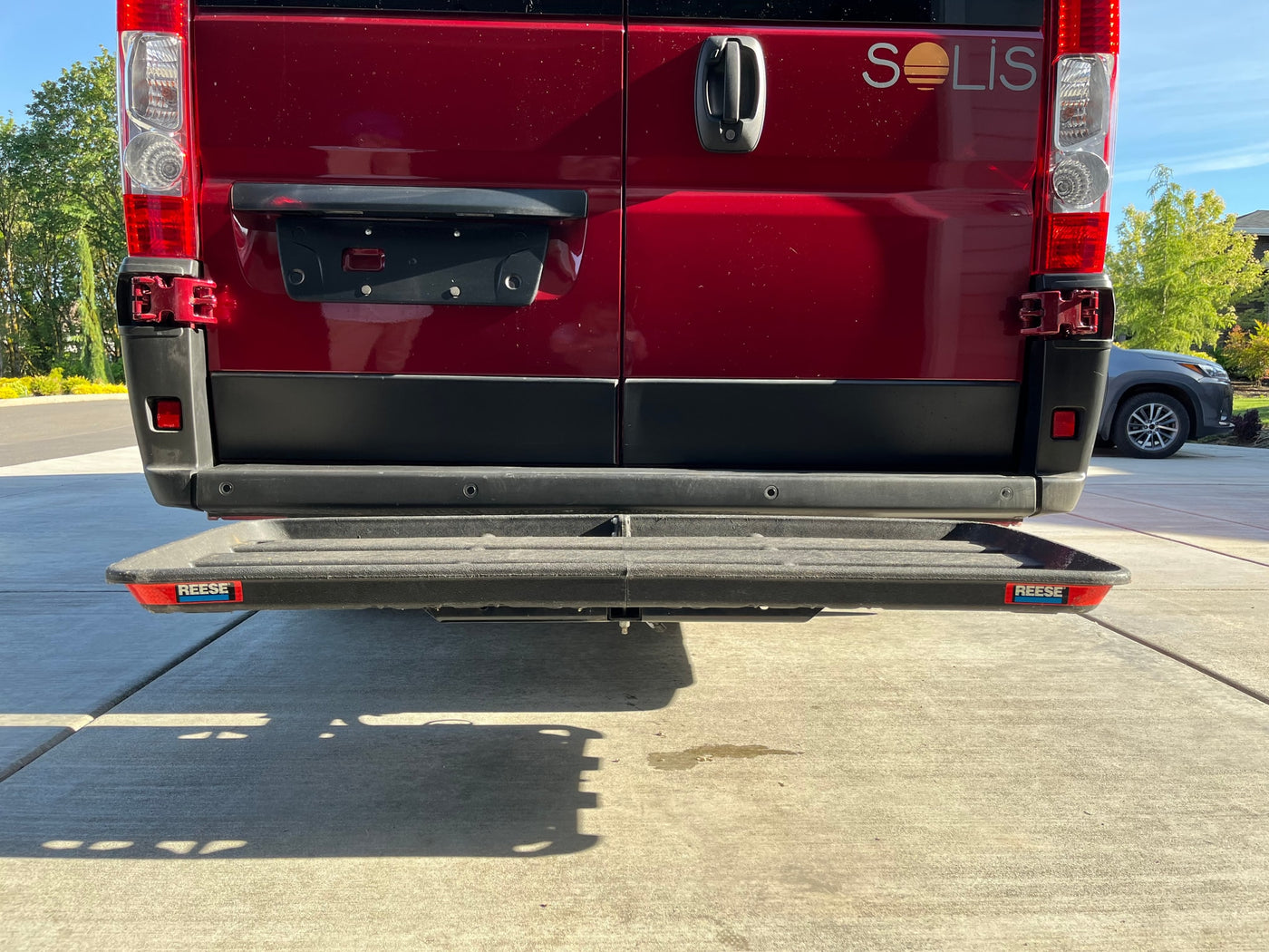 Rear view of a red Winnebago Solis RV, equipped with a Reese step. Consider this for your next rv rental. — photo 12