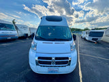 White RV rental van (WA plate CEU3379) in an RV parking area with other campers under a partly cloudy sky.