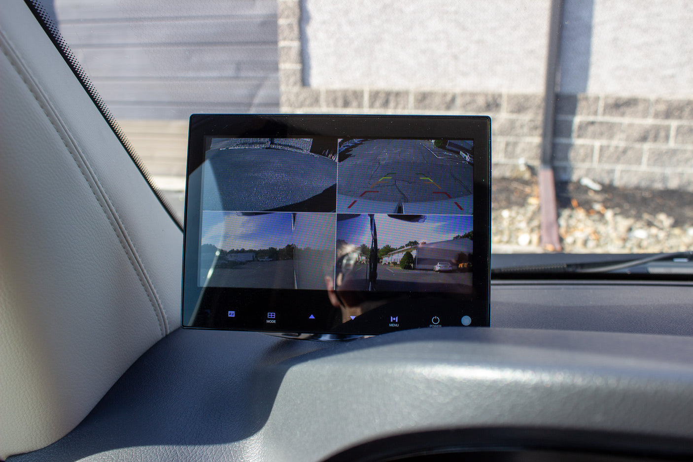 Dashboard monitor showing a 4-camera system with rear parking lines and surround views, essential for safe RV rental navigation.