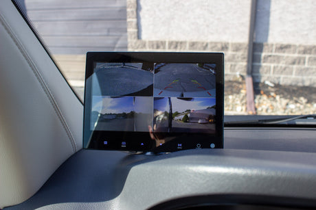 Dashboard monitor showing a 4-camera system with rear parking lines and surround views, essential for safe RV rental navigation.