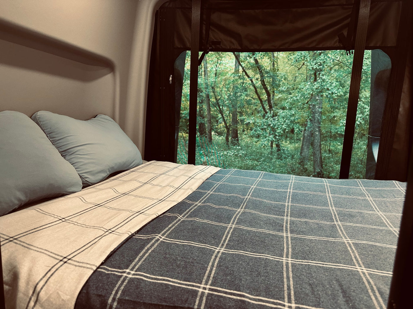 Comfortable RV rental bed with a serene forest view from the large window, perfect for camping and nature lovers. — photo 3