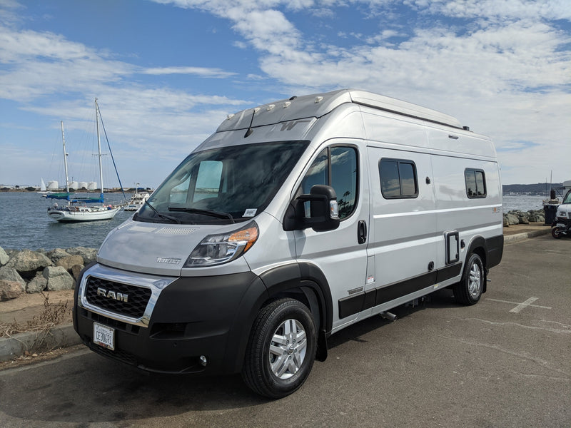  ready for your RV rental adventure.|Silver Winnebago Solis rv rental parked by a marina — photo 2