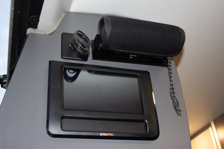 A mounted BMPRO tablet, portable speaker, and USB charger enhance an RV rental's interior tech.