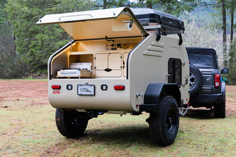 Teardrop RV rental: off-road camper with open outdoor kitchen & rooftop tent, ready for adventures in nature with an SUV.