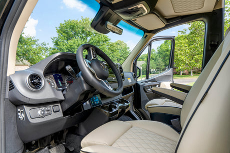 Explore the luxurious interior of this RV rental, featuring a modern driver's cockpit and comfortable seating.