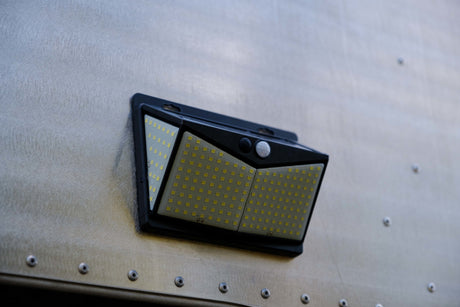 Solar-powered LED motion sensor light attached to an RV rental. Provides exterior illumination for your outdoor adventures.