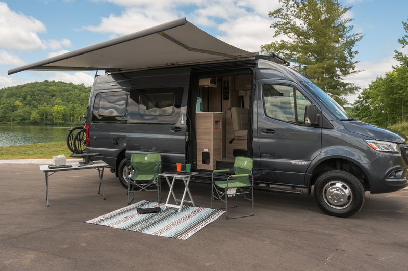 A dark grey Winnebago camper van rv rental with an awning — photo 1