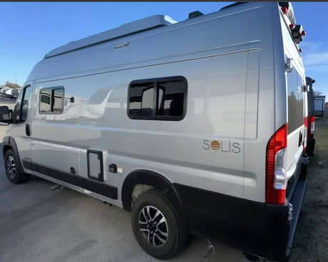 Silver Winnebago Solis camper van, ideal for rv rental adventures. Side view highlights its high roof and windows.