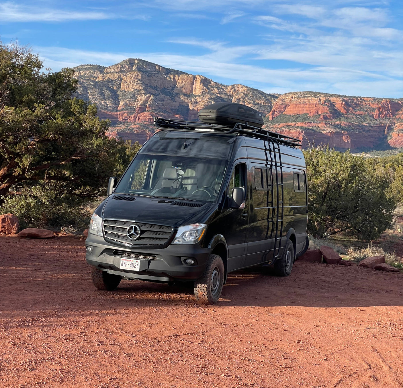 Black Mercedes Sprinter RV rental in a stunning red rock desert landscape. Ideal for your next adventure!