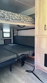 This RV rental features a flexible interior with a top bunk and a lower sofa that converts into a bed.