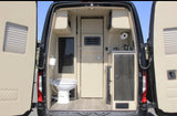 **RV rental**'s rear interior with open doors reveals a toilet, sink, and compact kitchen. Beige and dark wood design.
