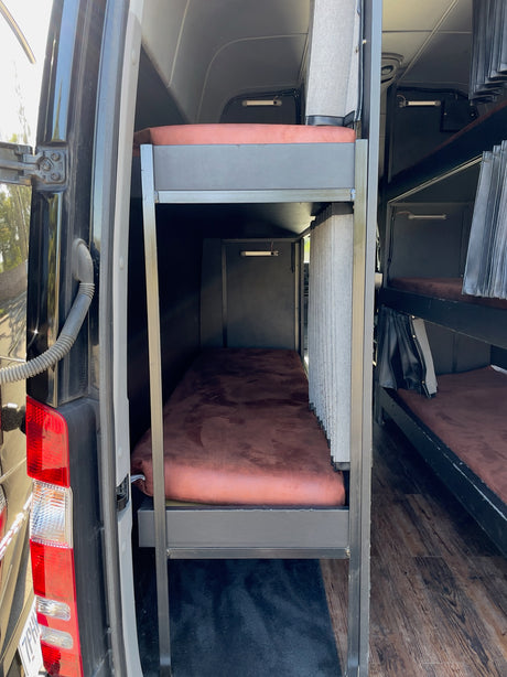 RV rental interior: Multiple bunk beds inside a custom sleeper van, perfect for group travel or tours.