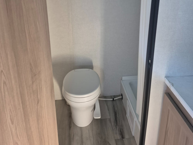  and bed with blue foam topper.|Compact RV rental kitchenette: features a black microwave — photo 7