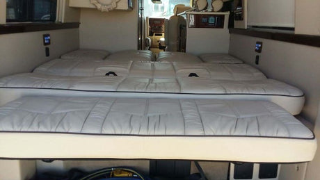 This RV rental offers comfortable, versatile two-tier white upholstered beds/seating, with controls visible for travel.